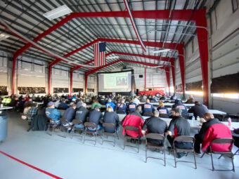 rows of people sitting inside at Tesla event